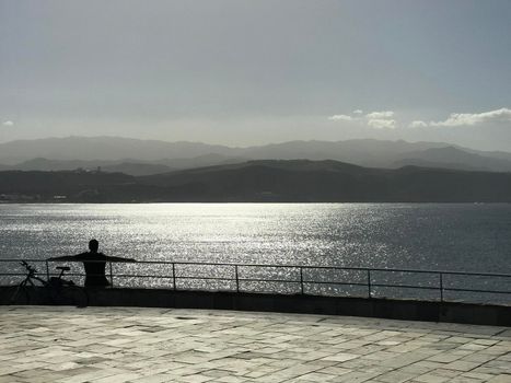 Shadow from a man and his bike enjoying the sun in Las Palmas Gran Canaria