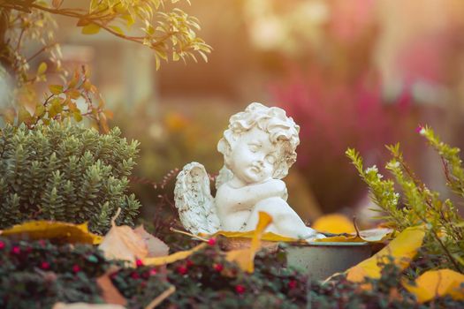 White angel on a grave at a cemetery, flowers