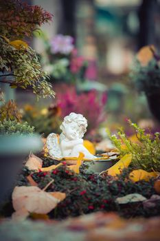 White angel on a grave at a cemetery, flowers