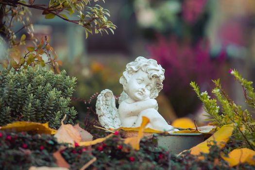 White angel on a grave at a cemetery, flowers