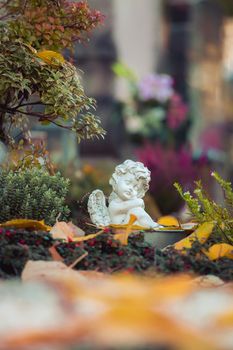 White angel on a grave at a cemetery, flowers