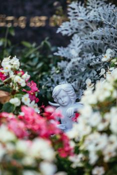 White angel on a grave at a cemetery, flowers