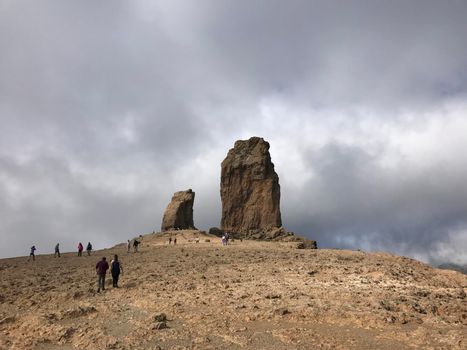 Tourist walking towards the Roque Nublo a volcanic rock on the island of Gran Canaria