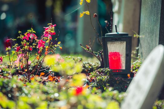 Candle in an iron lantern on a grave at a cemetery