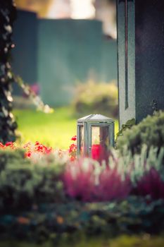 Candle in an iron lantern on a grave at a cemetery