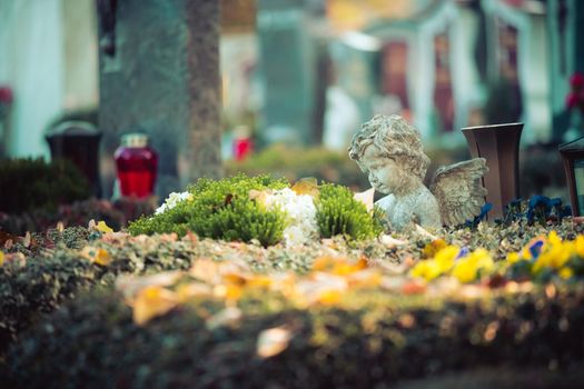 White angel on a grave at a cemetery, flowers
