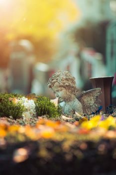 White angel on a grave at a cemetery, flowers