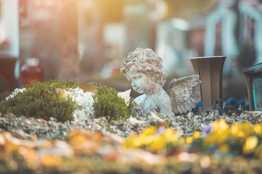 White angel on a grave at a cemetery, flowers