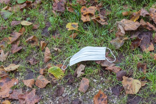 Environmental pollution concept: Single use face mask on the floor outdoors, waste