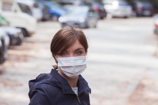 Young woman outdoors wearing a face mask. Corona and flu season.