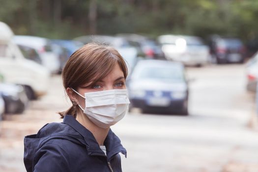 Young woman outdoors wearing a face mask. Corona and flu season.