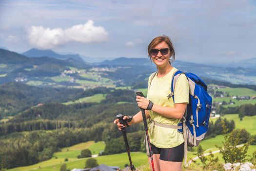 Young slim backpacker tourist girl is enjoying the view on rocky mountain, Austria