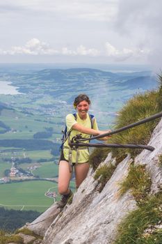 Young slim backpacker tourist girl climbing on rocky mountain, Austria