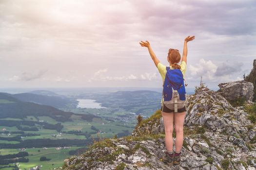 Young slim backpacker tourist girl is enjoying the view on rocky mountain, Austria