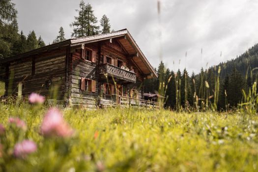 Mountain chalet and cloudy sky in Austria: Idyllic landscape in the Alps