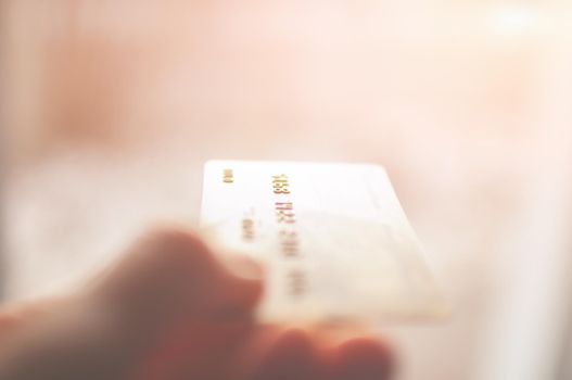 bank card of gold color in hands on a background of sunlight