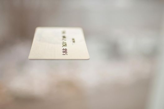 bank card of gold color on a background of beige color in the air
