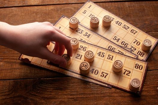 family vintage interesting lotto bingo game, hand holds a keg with a number