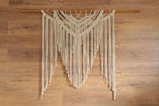 Macrame wall panel. A minimal, stylish, trendy concept with a beautiful background with light neutral colors.