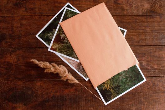 photos are enclosed in a beige envelope, located on a brown wooden table