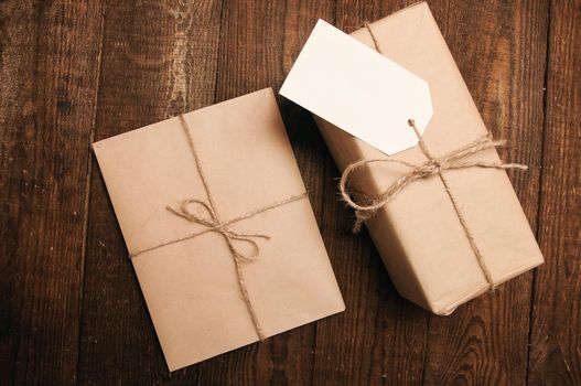 Gift for the holiday with an envelope on a wooden background