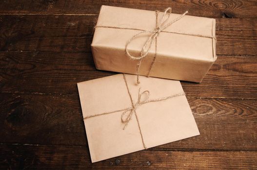Gift for the holiday with an envelope on a wooden background
