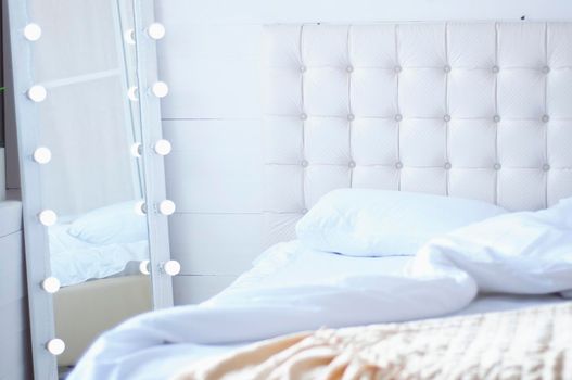 bouquet of flowers on the bed and a mirror with light bulbs