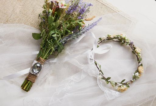 delicate wedding wreath in boho style on the table covered with a wedding veil