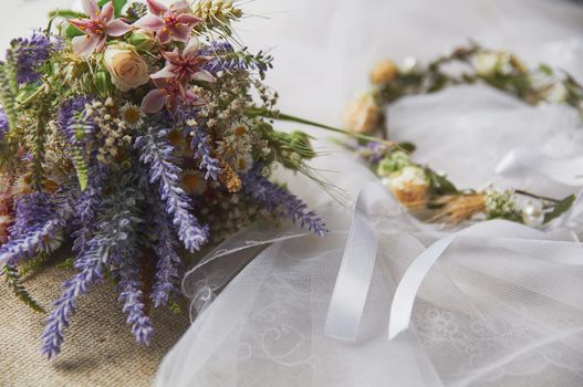 delicate wedding wreath in boho style on the table covered with a wedding veil