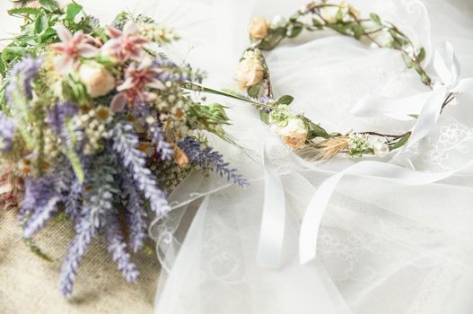 delicate wedding wreath in boho style on the table covered with a wedding veil