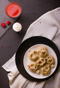 Manti or manty dumplings in a traditional bowl on wooden table