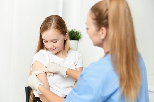 female doctor next to girl vaccination health treatment. High quality photo