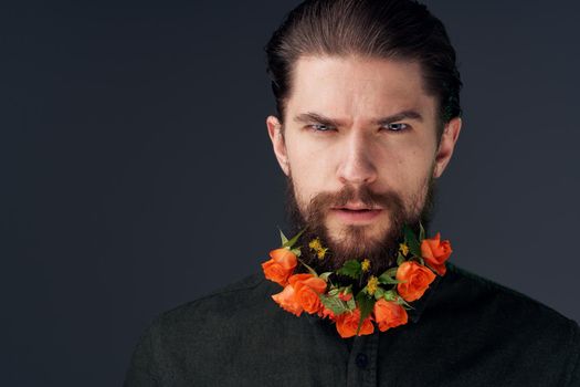 man flowers decoration in beard emotions black background. High quality photo