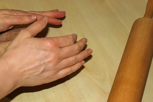 Fresh pizza dough made by female hands