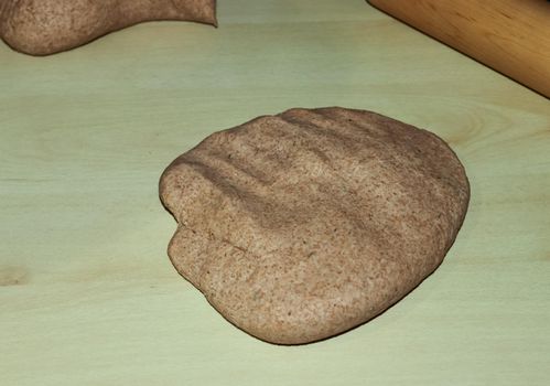 Fresh pizza dough made by female hands