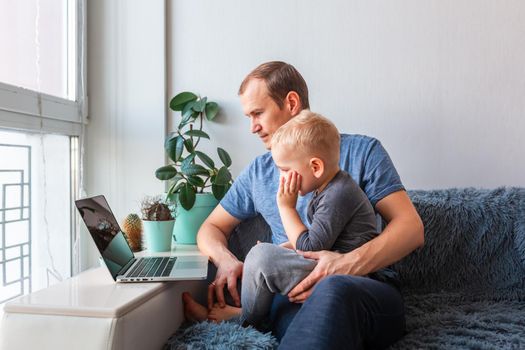 Father and son having video call with grandparents on laptop during covid quarantine lockdown. Stay at home, distance communication concept