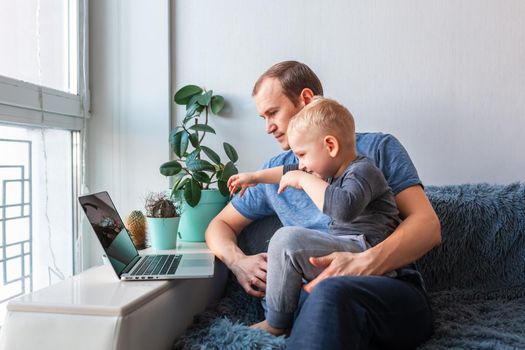 Father and son having video call with grandparents on laptop during covid quarantine lockdown. Stay at home, distance communication concept