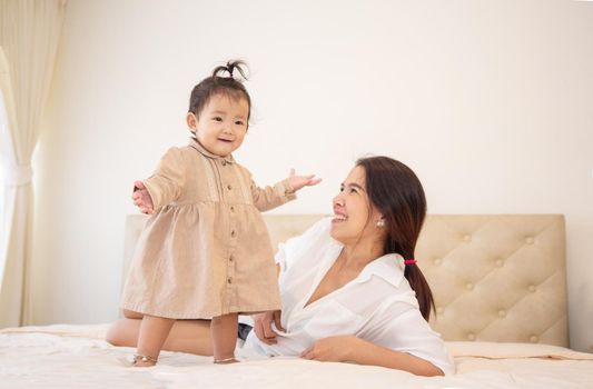 Portrait of a baby girl on the bed in bedroom