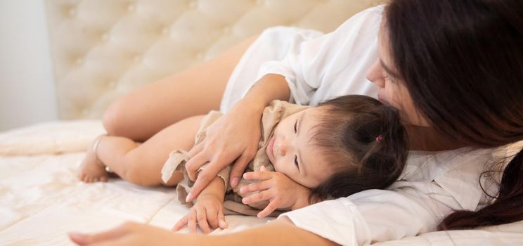 Portrait of a baby girl on the bed in bedroom