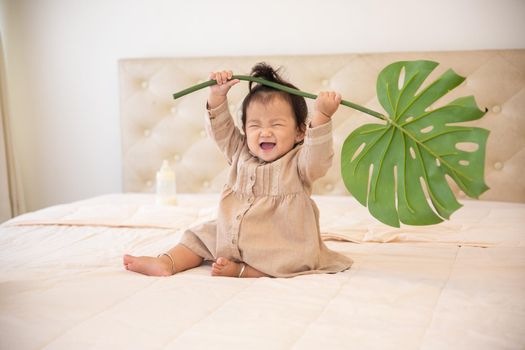 Portrait of a baby girl on the bed in bedroom