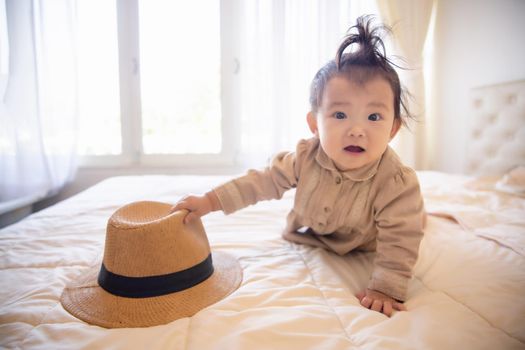 Portrait of a baby girl on the bed in bedroom