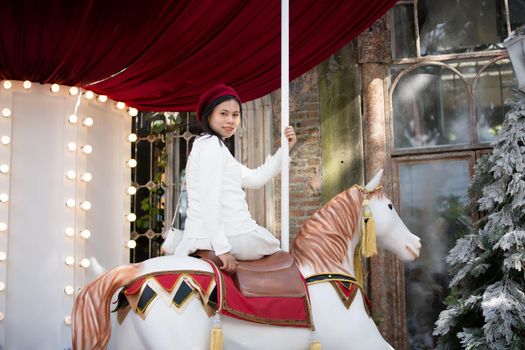 Young woman enjoying ride go around in the amusement park.