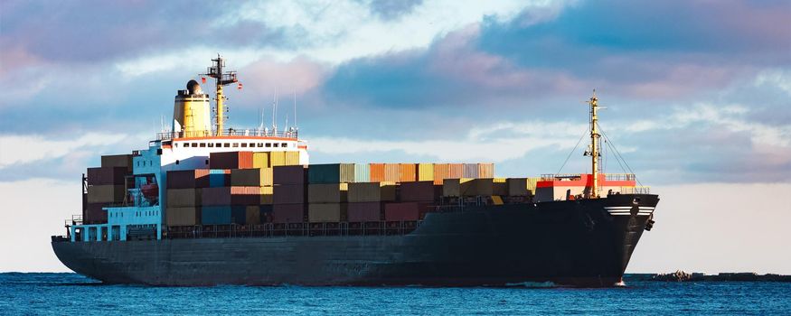 Modern black container ship moving from Baltic sea