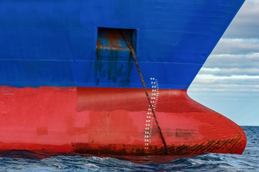 Blue cargo ship moored in still Baltic sea water