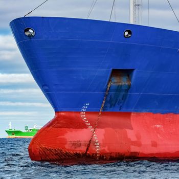 Blue cargo ship moored in still Baltic sea water