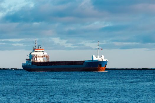 Blue bulk carrier sailing in still water