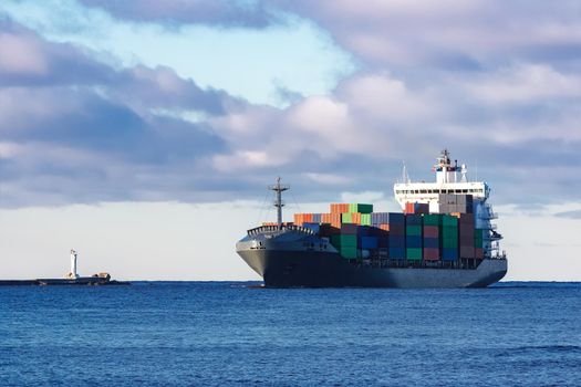 Modern grey container ship moving in still water