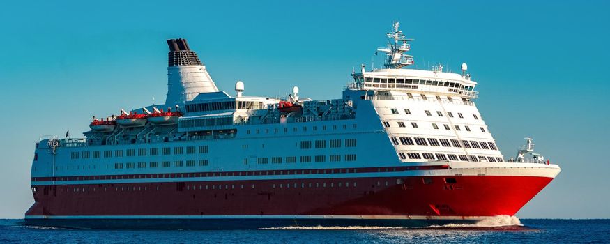 Red cruise liner. Large passenger ferry underway