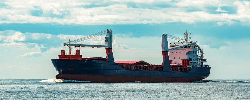 Merchandise import. Large blue cargo ship moving to Riga port