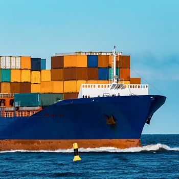 Blue container ship in travel. Logistics and freight industry